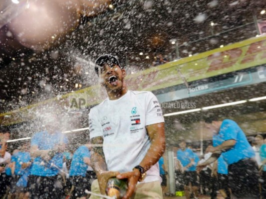 El piloto de Mercedes Lewis Hamilton rocía champaña luego de ganar el Gran Premio de Abu Dabi, en el circuito Yas Marina, el domingo 25 de noviembre de 2018.