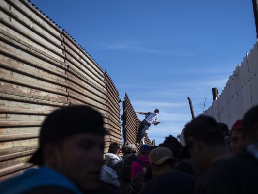 Fotos del momento en el que migrantes de la caravana saltaron valla fronteriza de Estados Unidos, pero fueron detenidos con gases lacrimógenos