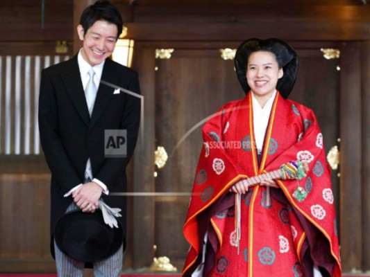 La princesa japonesa Ayako, a la derecha, vestida con una túnica ceremonial tradicional, y el novio Kei Moriya, a la izquierda, hablan con los periodistas después de su ceremonia de boda en el Santuario Meiji en Tokio, el lunes 29 de octubre de 2018.