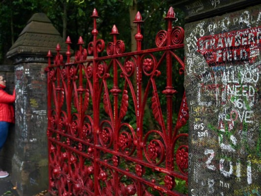 Los visitantes escriben en la pared junto a las puertas de Strawberry Field en Liverpool, noroeste de Inglaterra. Foto: AFP.