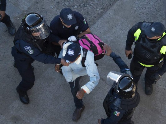 Fotos del momento en el que migrantes de la caravana saltaron valla fronteriza de Estados Unidos, pero fueron detenidos con gases lacrimógenos