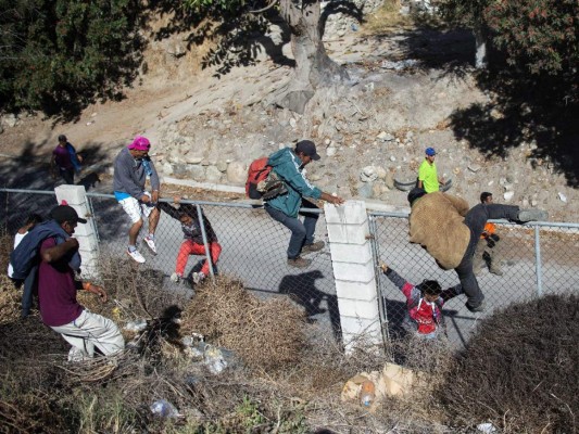 Fotos del momento en el que migrantes de la caravana saltaron valla fronteriza de Estados Unidos, pero fueron detenidos con gases lacrimógenos