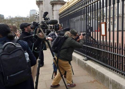 Fotografía de archivo del viernes 9 de abril de 2021, de miembros de los medios de comunicación tomando imágenes de un anuncio sobre la muerte del príncipe Felipe de Gran Bretaña, exhibido en la cerca del Palacio de Buckingham en Londres. Foto: AP