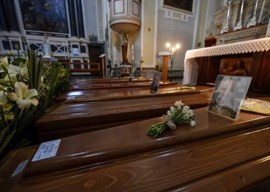 Coffins wait to be transported to cemetery, in the church of Serina, near Bergamo, Northern Italy, Saturday, March 21, 2020. Italyâs tally of coronavirus cases and deaths keeps rising, with new day-to-day highs: 793 dead and 6,557 new cases. For most people, the new coronavirus causes only mild or moderate symptoms. For some it can cause more severe illness. (Claudio Furlan/LaPresse via AP)