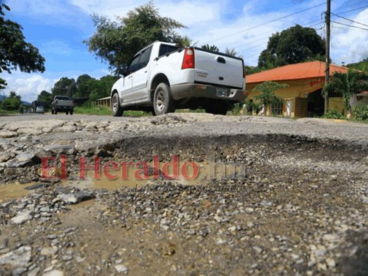Los enormes baches a lo largo de la carretera arruinan los amortiguadores de los carros.