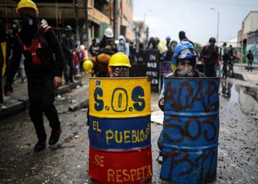 Manifestantes antigubernamentales se resguardan detrás de escudos de fabricación casera durante enfrentamientos con la policía en Bogotá. (AP Foto/Iván Valencia, Archivo).