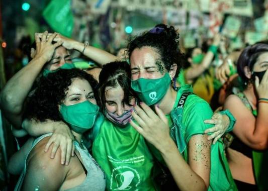 Activistas pro-aborto celebran después de que el Senado aprobó un proyecto de ley para legalizar el aborto fuera del Congreso en Buenos Aires el 30 de diciembre de 2020. Foto: AFP