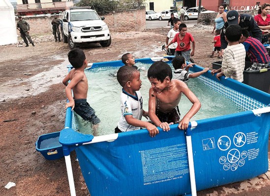 Honduras: Policías instalan piscinas para que niños bañen