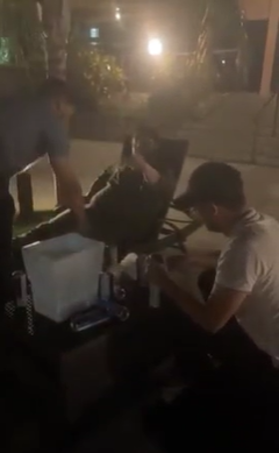 El congresista trata de decir que lo están grabando mientras otra persona oculta las cervezas.