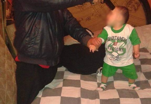 Apunta con arma a bebé