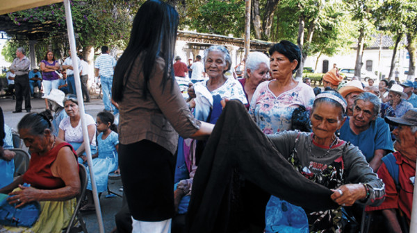 Abuelos reciben comida, abrigos y gorros de Navidad