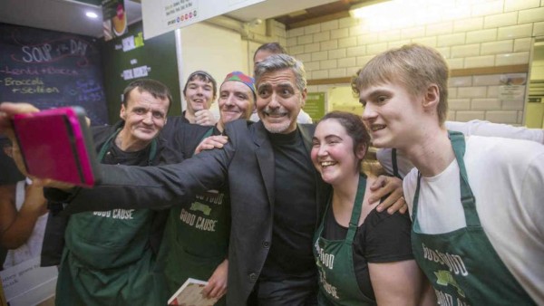 Clooney atrae multitud al visitar café para indigentes