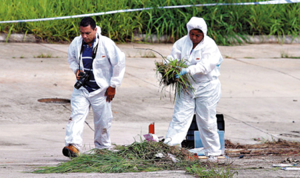Agentes buscan evidencias en la escena del crimen