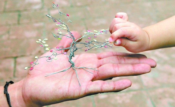 Los pequeños no dejan de acercarse a ver cómo con un poco de ingenio Brayan convierte el alambre en verdadera obras de arte con las cuales no solo adorna los hogares de quienes las compran, sino que también deja un mensaje de amor y cuidado ecológico.