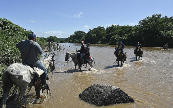 A caballo y en balsas, nicaragüenses cruzan hacia Honduras a vacunarse contra el covid-19