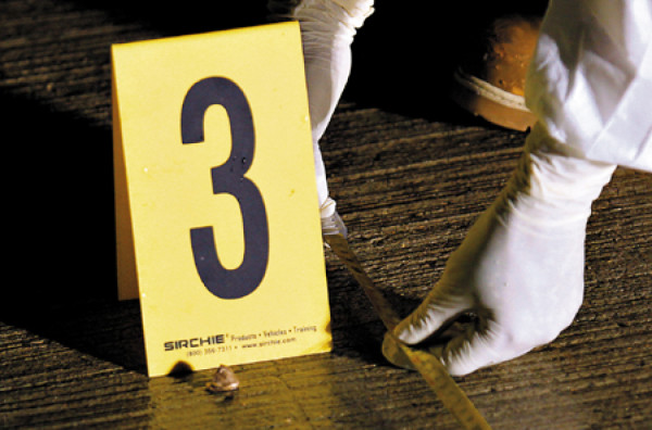 Agentes buscan evidencias en la escena del crimen