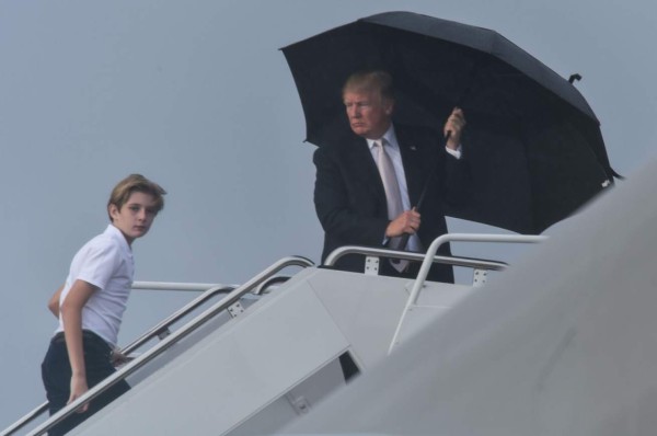 Trump se cubre de la lluvia mientras Melania y su hijo Barron se mojan (FOTOS)