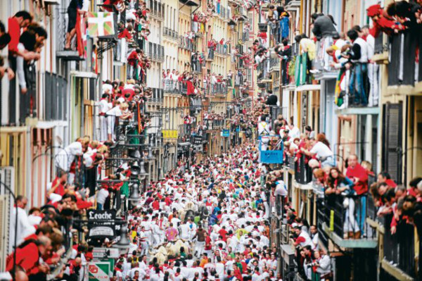 Mozos de rojo y blanco en las calles de Pamplona