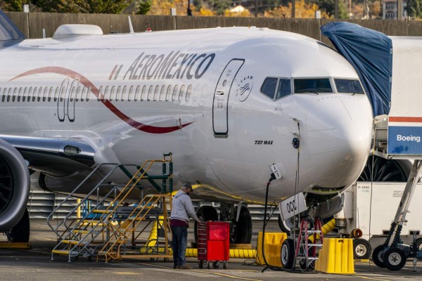 Un trabajador se para debajo de un avión Boeing 737 Max mientras está estacionado en las instalaciones de producción de Renton de la compañía el 13 de noviembre de 2020 en Renton, Washington, Estados Unidos. Foto: AFP