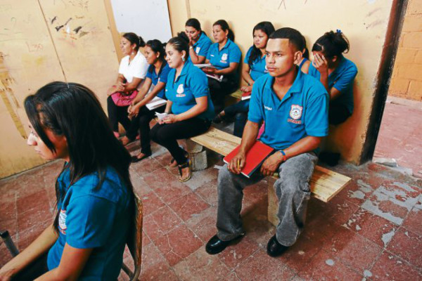 Reciben clases sentados en tablas y bloques