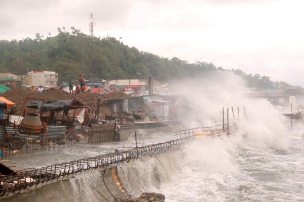 Fuertes olas causadas por el tifón Vongfong golpean las casas próximas a la costa en la ciudad de Catbalogan, en la provincia de Samar Occidental, en el este de Filipinas, el 14 de mayo de 2020. (AP Foto/Simvale Sayat)