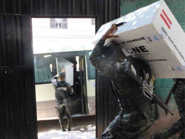 Elementos de las Fuerzas Armadas resguardan maletas electorales durante el proceso de distribución.