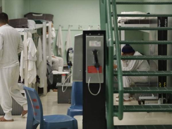 Se muestra un teléfono público cerca de detenidos en un área de dormitorios durante un recorrido de prensa a un centro de detención del Servicio de Control de Inmigración y Aduanas en Tacoma, Washington. Foto: AP.