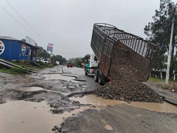 El mal estado de la carretera CA-13, en el litoral de Honduras, ha obligado a empresarios locales a tapar los baches con arena.