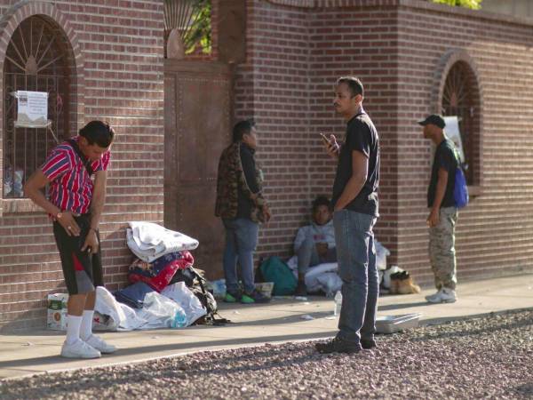 Decenas de migrantes esperan afuera de un albergue en Minnesota para espera de resolver su situación legal.