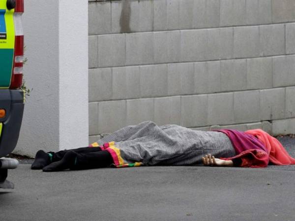 Un cadáver yace en el piso afuera de una mezquita de Christchurch, Nueva Zelanda, el viernes 15 de marzo del 2019, tras una masacre. (AP Foto/Mark Baker)