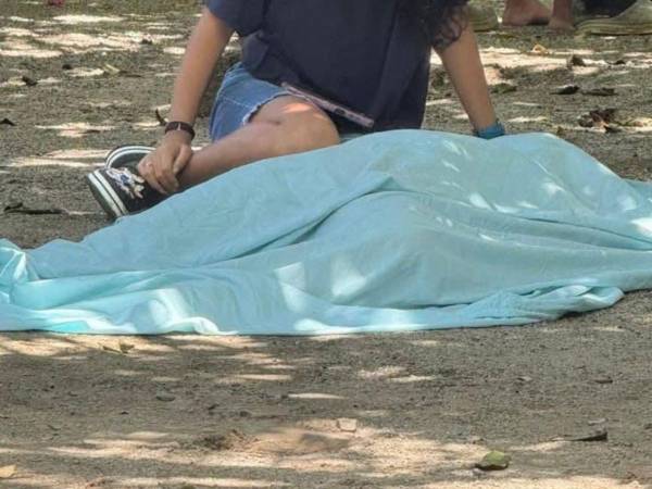 Una joven llora sobre el cadáver de Gilma María Morales asesinada en la ciudad de La Ceiba.