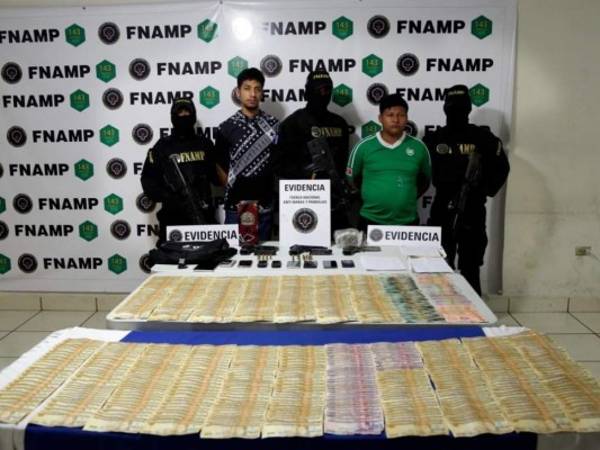 Los dos supuestos pandilleros detenidos junto a la evidencia. Foto: EL HERALDO