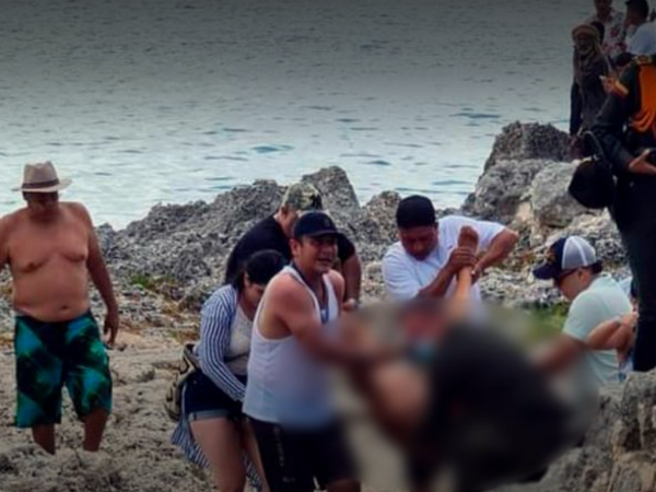 Momento en que otros bañistas y rescatistas sacaban del agua el cuerpo del turista.
