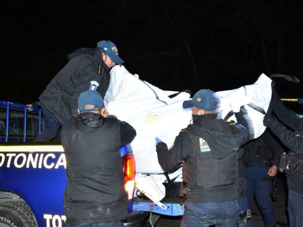 Miembros de las fuerzas de seguridad guatemaltecas proceden a retirar los cuerpos de las víctimas después de que al menos quince personas murieran en la noche del viernes y otras diecinueve resultaran heridas durante un accidente de un bus de transporte público en el oeste de Guatemala, según confirmaron este sábado los cuerpos de socorro.