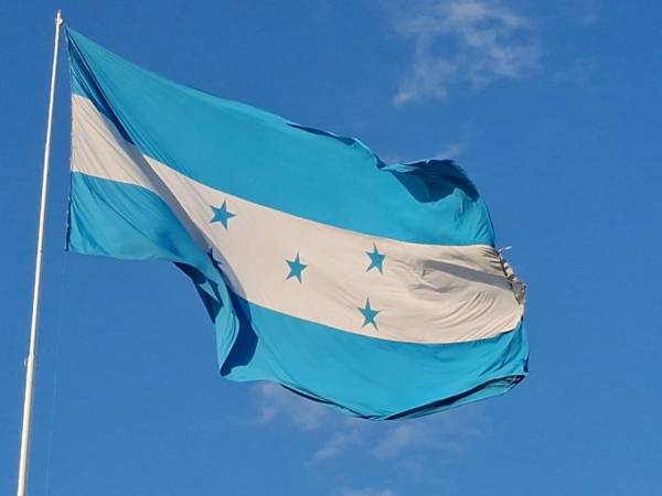 La Bandera Nacional de Honduras, adoptada el 16 de febrero de 1866, tiene tres franjas horizontales: dos azules que representan los océanos que rodean al país y una blanca que simboliza la paz. En el centro hay cinco estrellas azules en forma de X, representando a los cinco países de Centroamérica, con Honduras al centro como símbolo de unión.