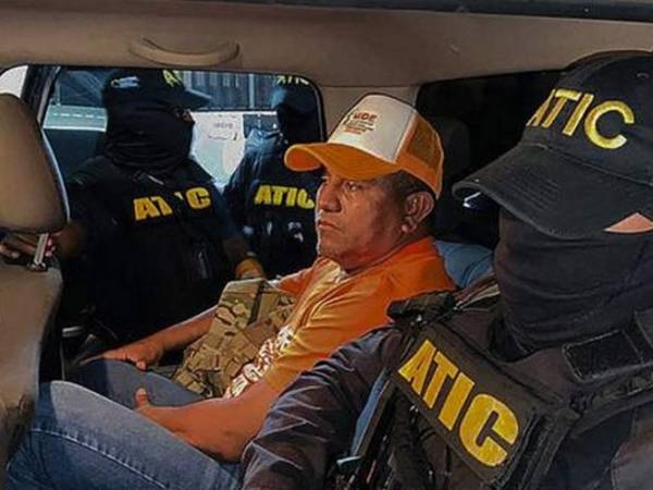 Miembros de ATIC escoltando al exmilitar Santos Rodríguez Orellana después de ser arrestado por cargos de lavado de activos, en Tegucigalpa. Foto AFP