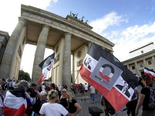 Personas con banderas con la cara del presidente estadounidense Donald Trump asisten a una manifestaciÃ³n contra las restricciones por la pandemia frente a la Puerta de Brandenburgo en BerlÃ­n, Alemania, el sÃ¡bado 29 de agosto de 2020. (AP Foto/Michael Sohn)
