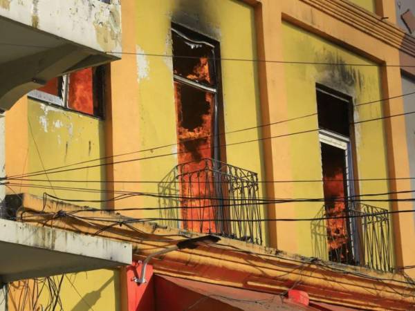 Bomberos combatieron el incendio que afectó varios locales comerciales en la tercera avenida del barrio El Centro de San Pedro Sula.