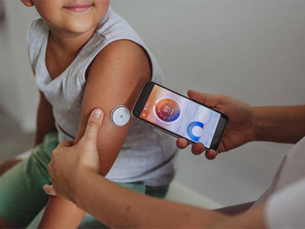 Una persona realiza monitoreo de glucosa a un niño.