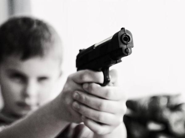 Imagen ilustrativa de un niño sosteniendo un arma.