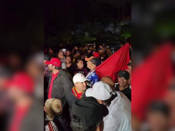 Con banderas de Libre se encuentran varias personas afuera de la Alcaldía Municipal.