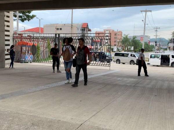 Estudiantes universitarios ingresan por el porton principal de la Universidad Nacional Autónoma de Honduras en el valle de Sula.