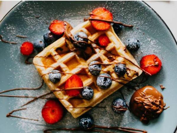Esta preparación se caracteriza por su masa suave y su inconfundible forma cuadriculada, que se consigue al cocinarla en una wafflera.