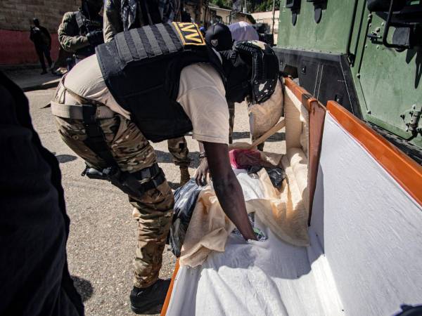 Un integrante de la Policía Nacional Haitiana (PHN), revisa un ataúd en busca de armas y drogas, durante un operativo contra las bandas armadas este martes, en Kenscoff (Haití).