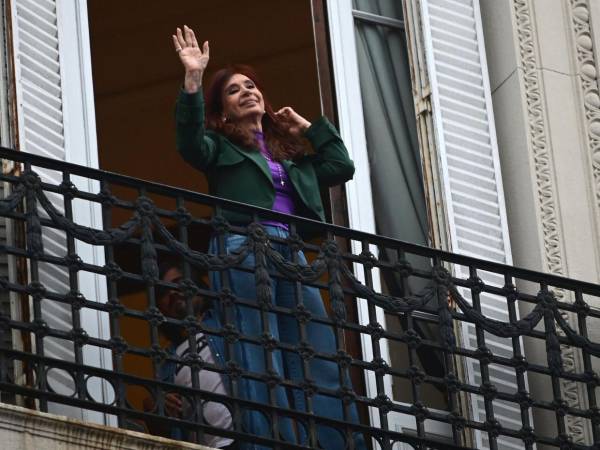 <b>FALLO.</b> La expresidenta de Argentina, Cristina Fernández saluda a sus seguidores desde el balcón de su casa al cumplirse un año de su condena por corrupción y los manifiestos de su partido, el peronismo, de que su líder es víctima de persecución política.