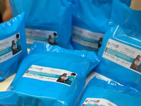 Personal de la farmacia prepara paquetes de medicamentos para enviarlos a los pacientes.