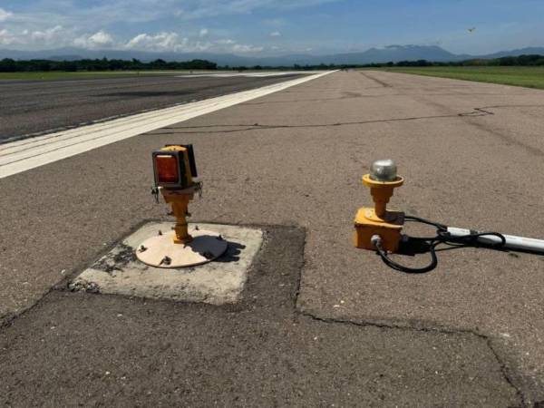 Las luces profesionales ya están instaladas (izquierda) en el Aeropuerto de Palmerola, pero la terminal opera con dispositivos provisionales, lo que causa incomodidad en Estados Unidos.