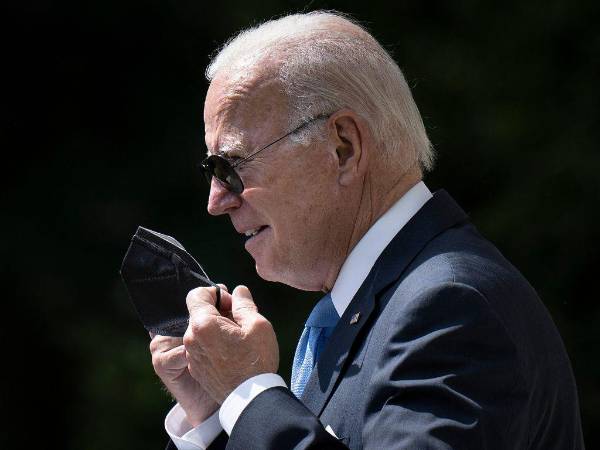 En esta foto de archivo tomada el 27 de julio de 2022, el presidente de los Estados Unidos, Joe Biden, se quita la máscara protectora mientras llega para pronunciar declaraciones en el jardín de rosas de la Casa Blanca en Washington, DC.