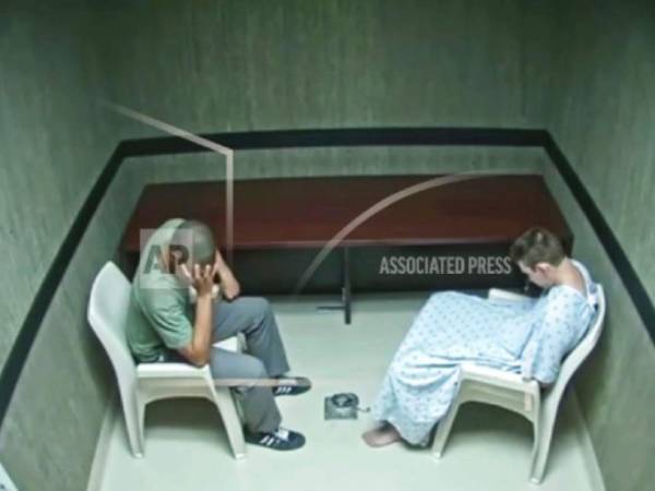 En esta imagen hecha a partir del vídeo proporcionado el miércoles 8 de agosto de 2018 por la Oficina del Sheriff del Condado de Broward, Zachary Cruz, a la izquierda, reacciona mientras hablaba con su hermano Nikolas Cruz en una sala de interrogatorios en Fort Lauderdale, Florida.