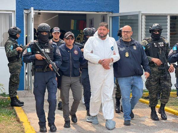 Esposa de pies y manos, el “Mojarras” salió acompañado de agentes de la DEA hacia el avión que lo llevará a Estados Unidos.